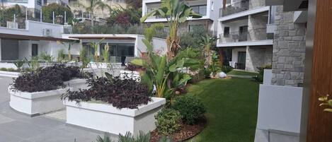 A modern residential complex with multiple two-story buildings, landscaped gardens, and a well-maintained lawn.