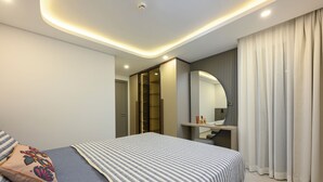 Une chambre à coucher moderne avec un lit, une table de chevet, un miroir et une armoire.