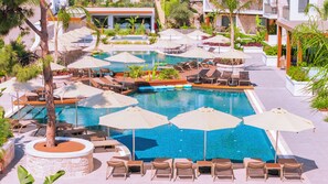 A large outdoor swimming pool with multiple lounge areas, sunbeds, and umbrellas. - Ayaz Suites (Bodrum)