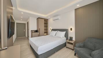 Une chambre d’hôtel moderne dotée d’un grand lit, de tables de chevet, d’un coin salon et d’une armoire intégrée.