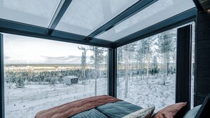 A bedroom with a large window overlooking a snowy landscape. - Arctic Lumo Resort (Kuusamo)