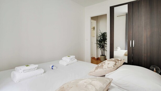 A hotel room with a bed, a wardrobe, and a potted plant. - Cosy Apartment - 1br/4p - Place de la Nation (Paris)