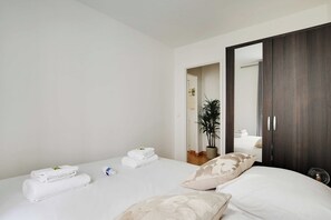 Ein Hotelzimmer mit einem Bett, einem Kleiderschrank und einer Zimmerpflanze.