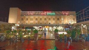 A hotel with a modern facade, signage for 'The Prince' and 'Zeno Xpress', and a well-lit entrance area with potted plants. - THE PRINCE ZENQ XPRESS RESORTT ROHTAK (Sampla)