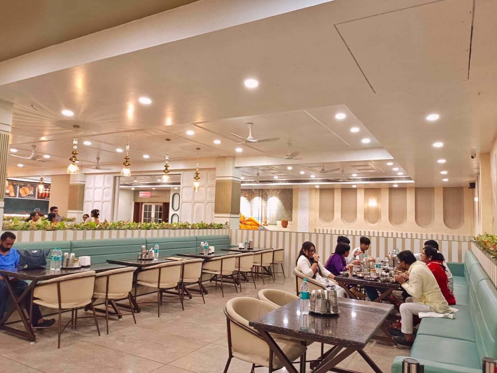 A spacious restaurant with multiple seating areas, including booths and tables, and a counter for ordering food.
