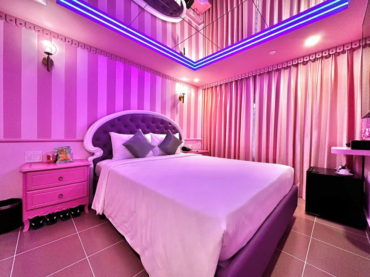 Un dormitorio con una cama grande, una mesita de noche y un aparador.