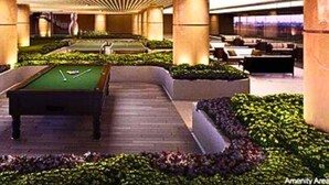 A pool table in a well-lit indoor area with a modern ceiling design and surrounding greenery. - Rent Xpress Online Heart of Makati (Makati)