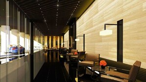 A modern hotel lobby with a long corridor, seating areas, and a reception desk. - Rent Xpress Online Heart of Makati (Makati)
