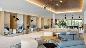 A spacious lobby with modern seating, a central coffee table, and a dining area in the background. - Fairfield by Marriott Inn & Suites Forrest City (Forrest City)