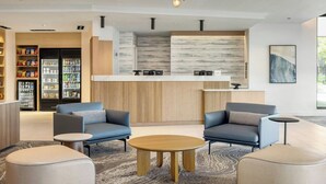 A modern lobby with seating, a reception desk, and a kitchen area. - Fairfield by Marriott Inn & Suites Forrest City (Forrest City)
