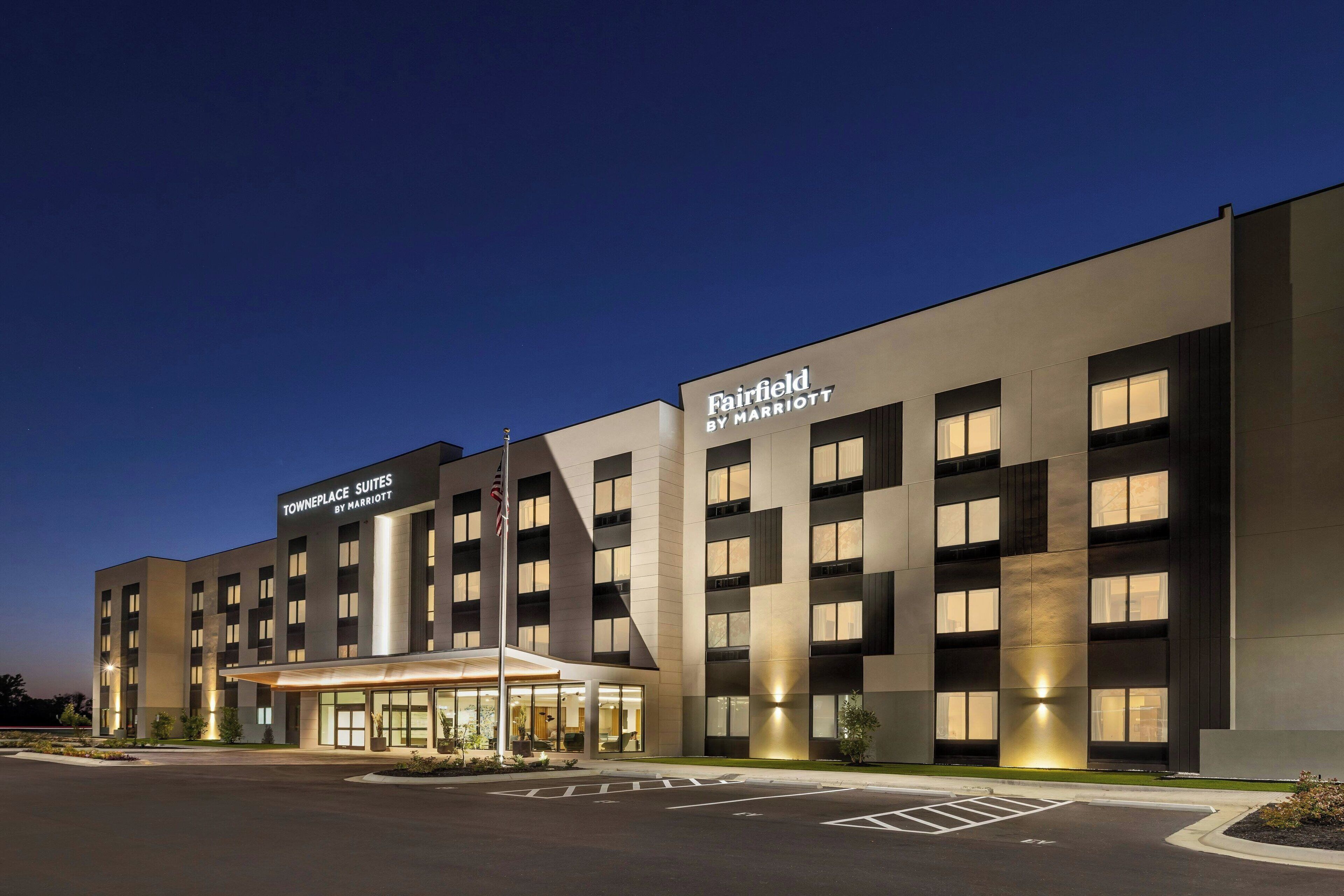 Un hotel moderno con un cartel grande para Fairfield by Marriott y TownePlace Suites.