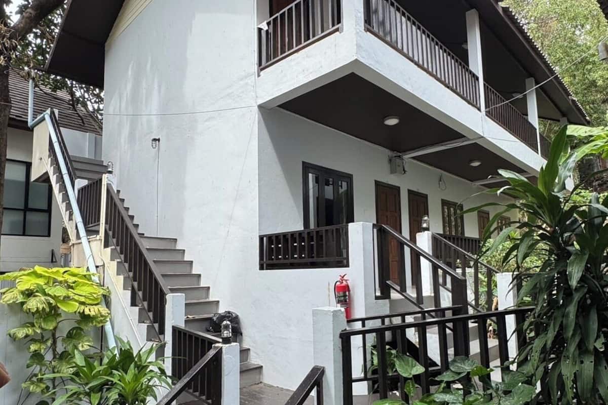 A two-story building with a balcony, a staircase, and a fire extinguisher.