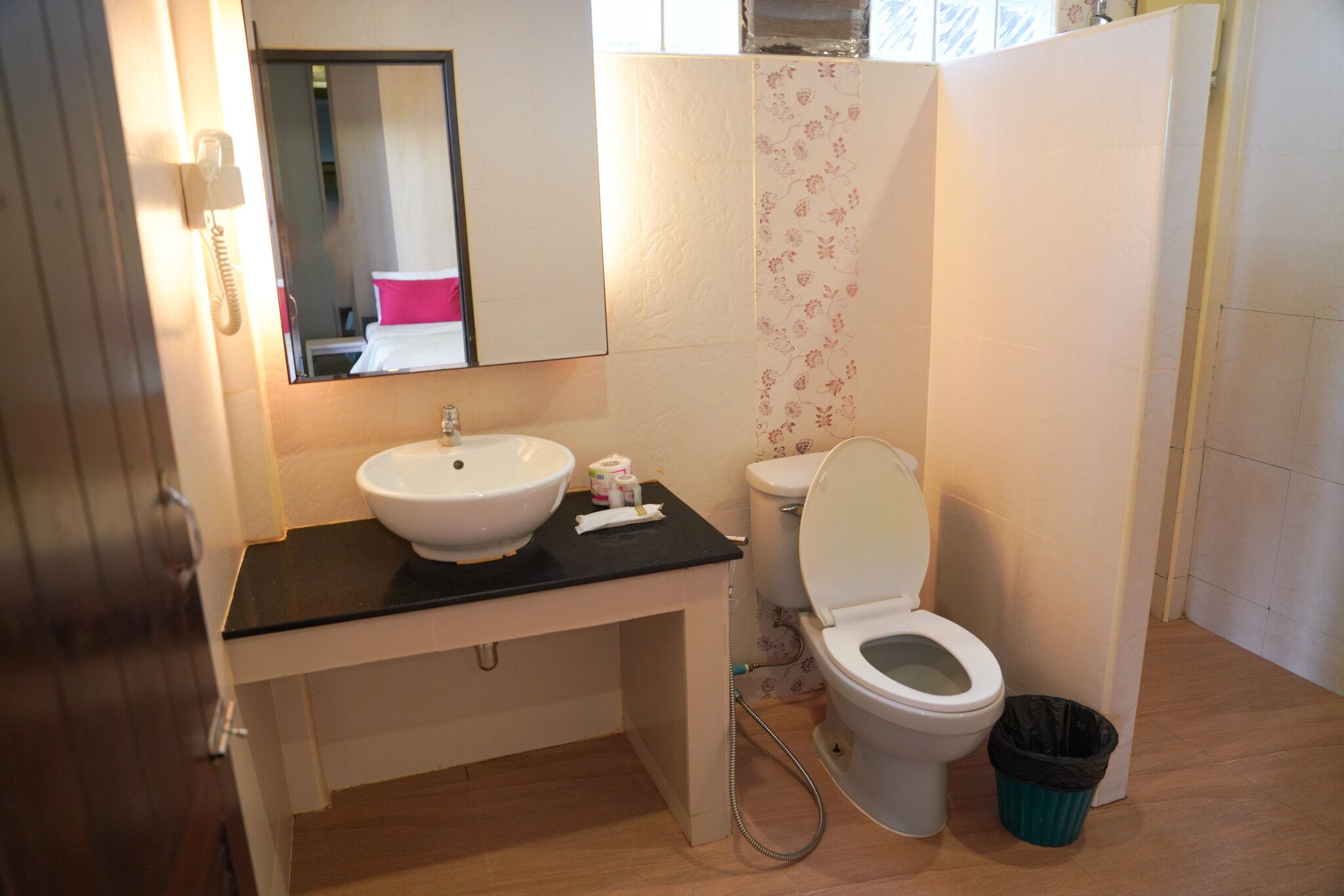 A bathroom with a sink, toilet, and a mirror.