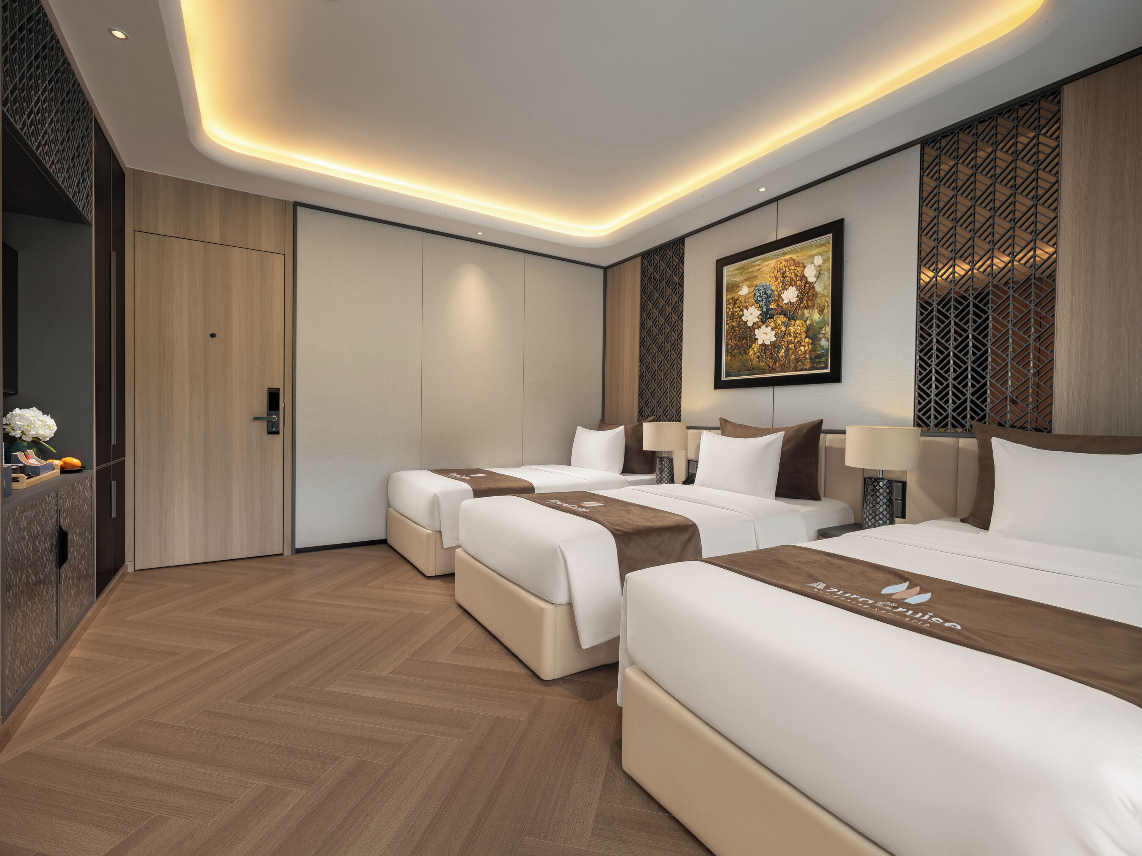 Ein Hotelzimmer mit drei Betten, Holzboden, einem großen Gemälde und einer dekorativen Wandverkleidung.