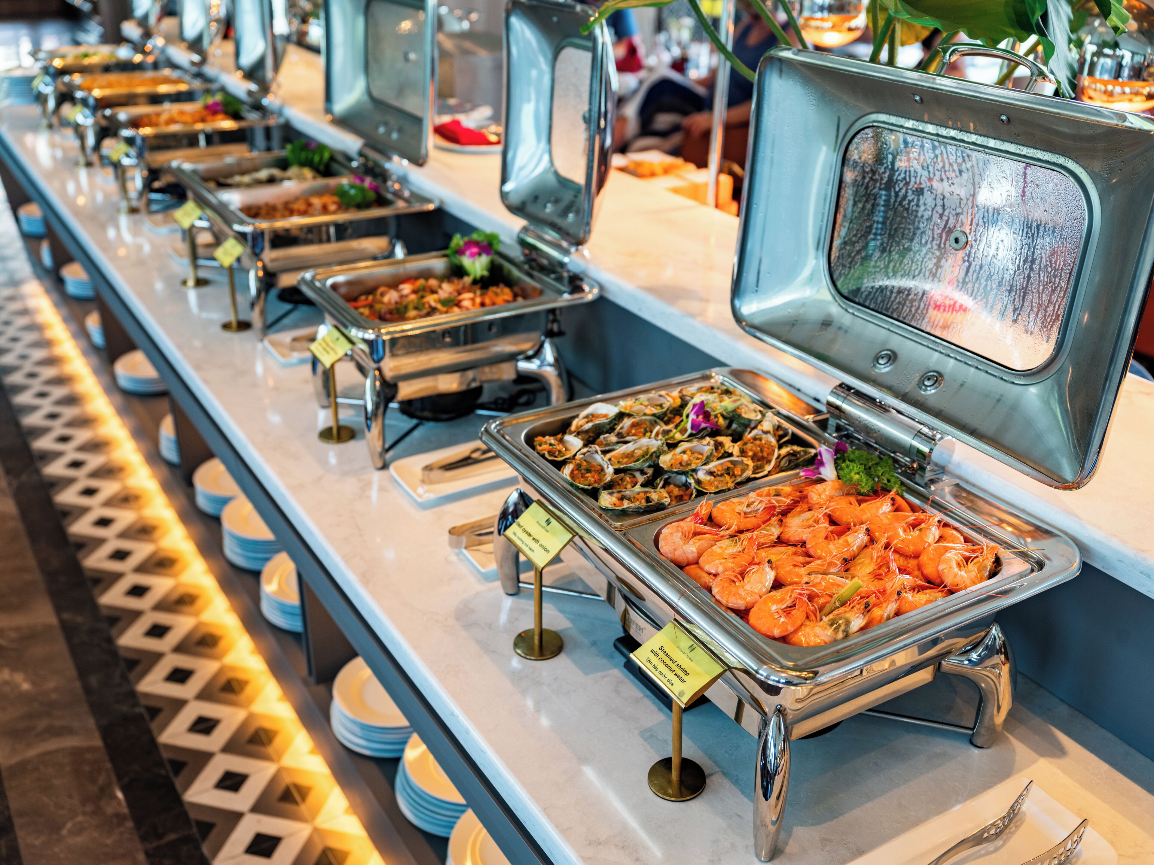 Un bufé con diversas opciones de comida, incluyendo camarones y mariscos.