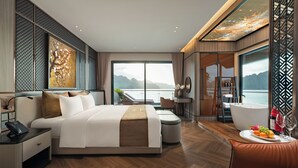 Une chambre d’hôtel moderne dotée d’un grand lit, d’un coin salon, d’une salle de bain et offrant une vue sur l’eau.