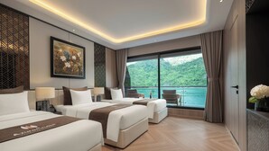 Une chambre d’hôtel moderne avec deux lits, une grande fenêtre donnant sur un plan d’eau et un balcon.