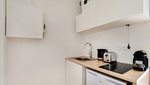 Eine kleine Küche mit Spüle, Toaster, Kaffeemaschine und Geschirrspüler.