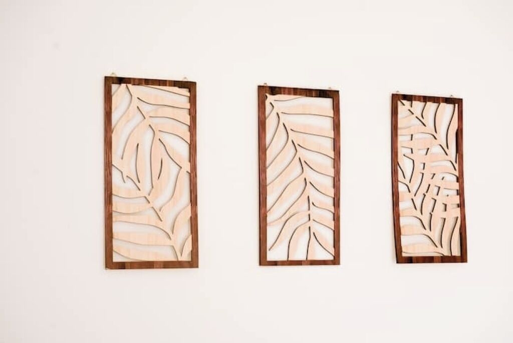 Three wooden panels with leaf patterns.