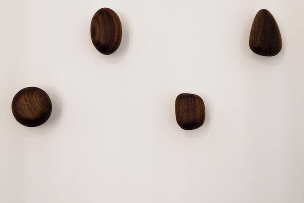 Quatre objets en bois de formes et de tailles différentes, sur un fond uni.