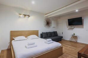 Apartamento | Tabla de planchar con plancha y ropa de cama