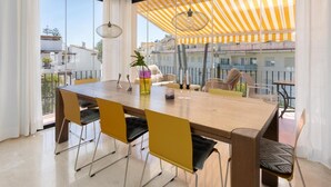 Un comedor con una mesa de madera, sillas amarillas y un dosel a rayas.