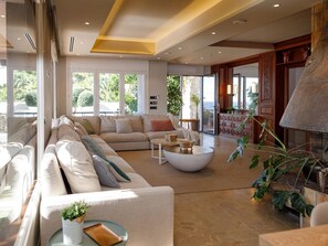 A spacious living room with a large sectional sofa, a round coffee table, and a fireplace. - Luxurious Villa La Paz Beach Port Aventura Golf (Salou)