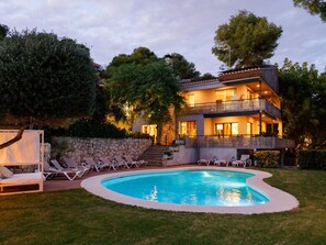 A two-story house with a swimming pool, outdoor seating, and a stone wall. - Luxurious Villa La Paz Beach Port Aventura Golf (Salou)
