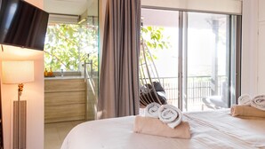 Een hotelkamer met een bed, een televisie, een lamp en uitzicht op het omliggende landschap.