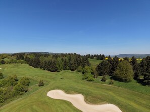 A golf course with sand bunkers, trees, and a clear blue sky. - Nature Resort Jakobsberg (Boppard)