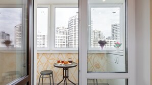 Eine kleine Küche mit Fenster, einem Tisch mit Stühlen und einem Blumentopf.