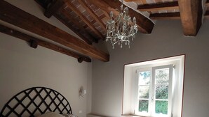 A bedroom with a bed, a window, and a chandelier. - Casina Laura (Capannori)