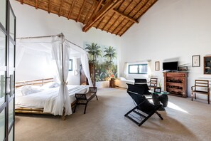 A bedroom with a four-poster bed, a desk with a chair, a television, and a wooden cabinet. - Guest Room 'Le Palmier Exotique' in Bazas with Shared Pool, Shared Terrace and Wi-Fi (Bazas)