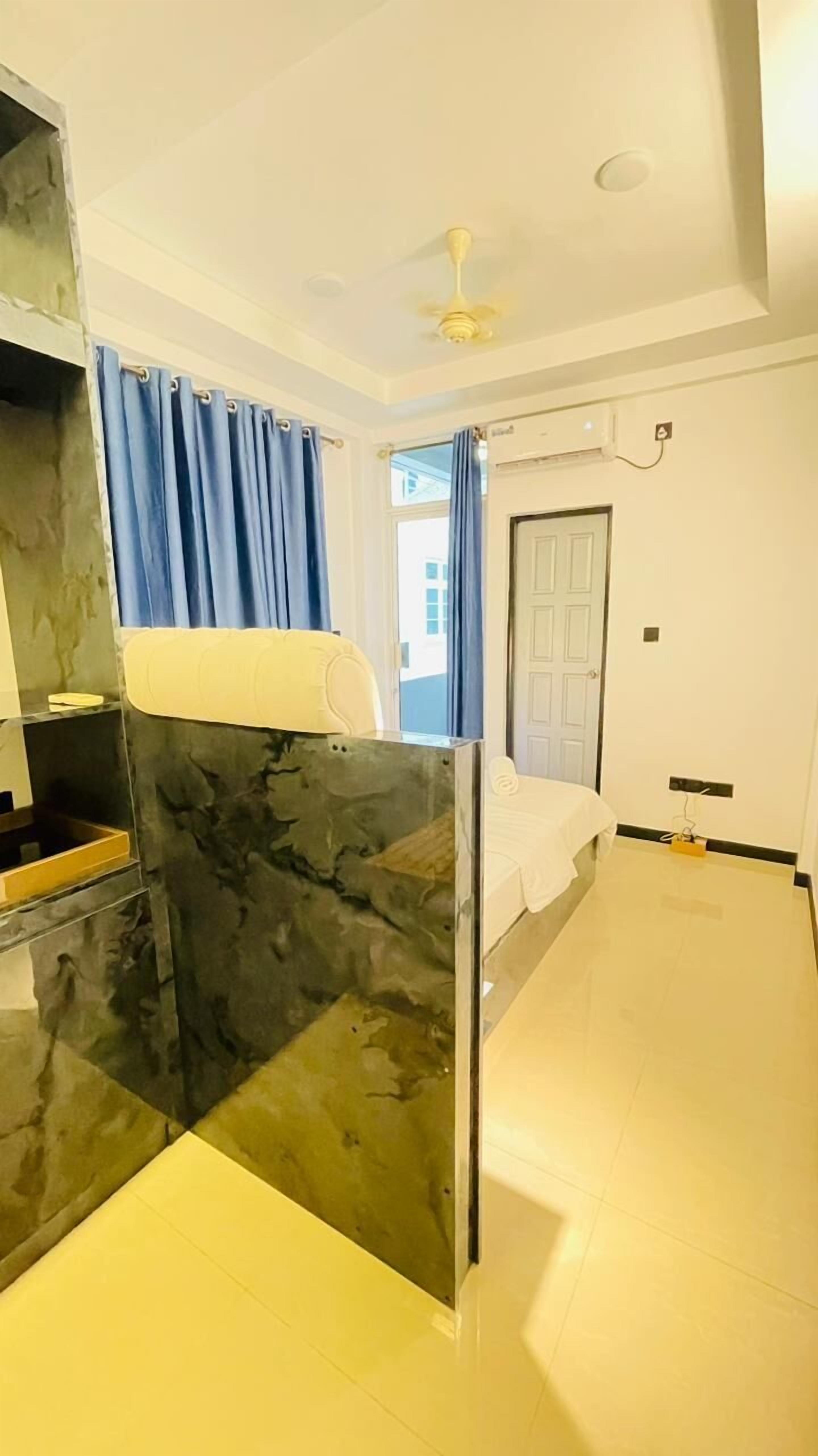 Un dormitorio moderno con cama, ventilador de techo y ventana con cortinas.