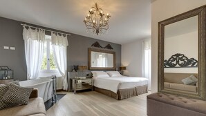 Una camera da letto con un letto grande, una cassettiera, una toeletta e una chaise longue.