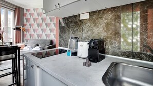 A modern kitchen with a marble backsplash, a coffee maker, a toaster, and a sink. - Peaceful Studio - 2P -near the Canal Saint-martin (Paris)