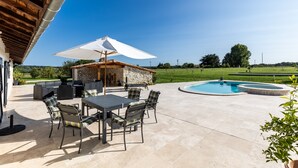 An outdoor patio with a pool, seating area, and stone structure. - Villa 'Le Basque' in Bazas with Shared Pool, Private Terrace and Wi-Fi (Bazas)