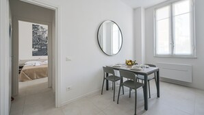 A modern hotel room with a dining area, a bed, a large window, and a mirror. - The Houses on the Park 2 (La Spezia)