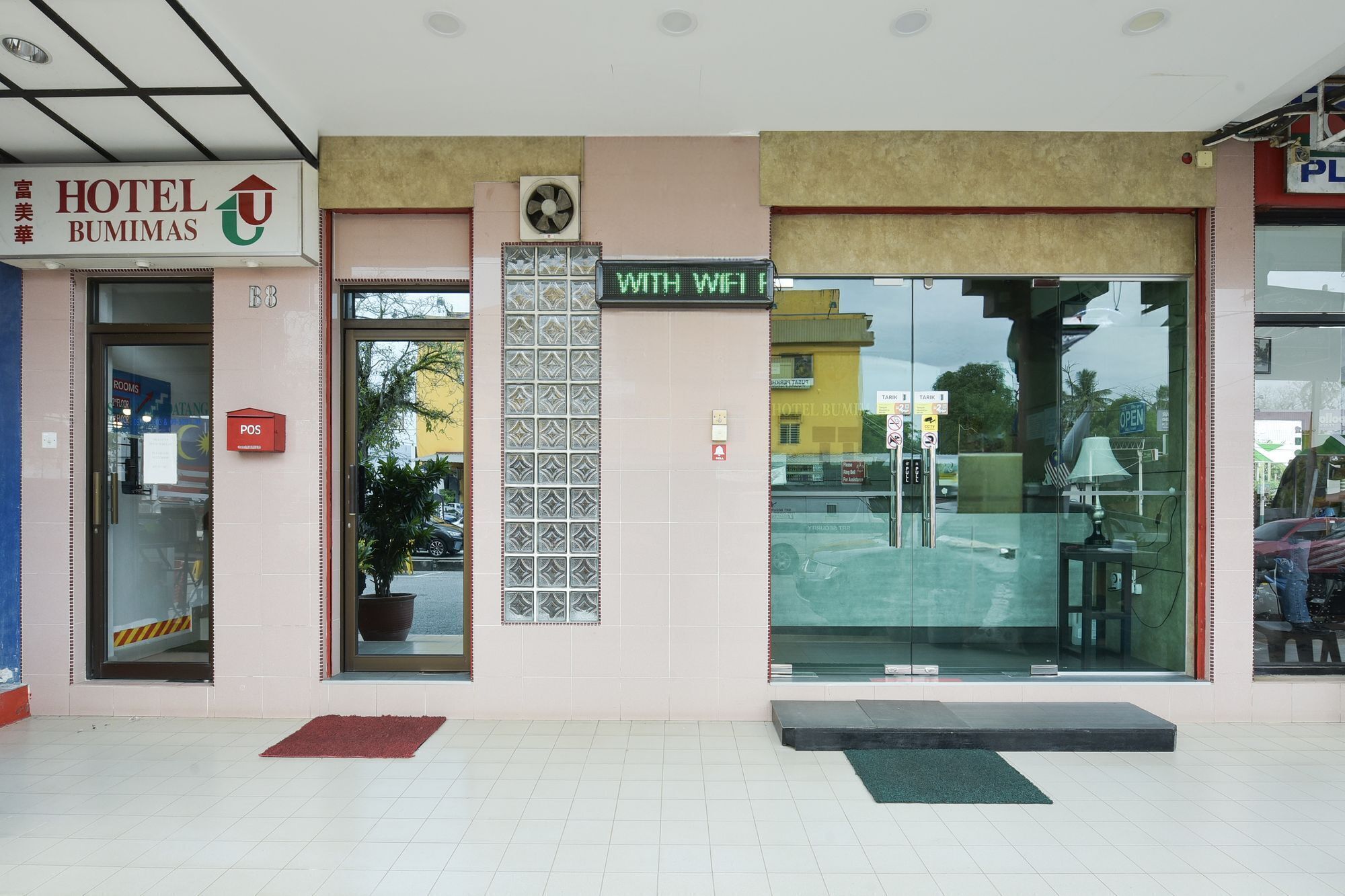La entrada del Hotel Bumimas con un cartel que indica acceso a WiFi.