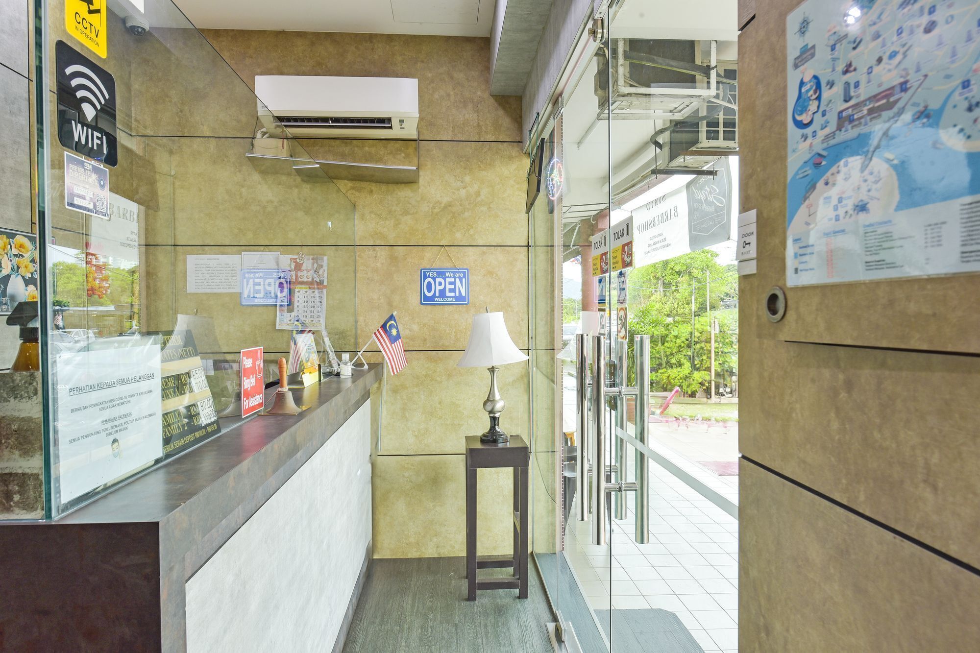 A reception area with a counter, a flag, a lamp, and a sign indicating the entrance is open.