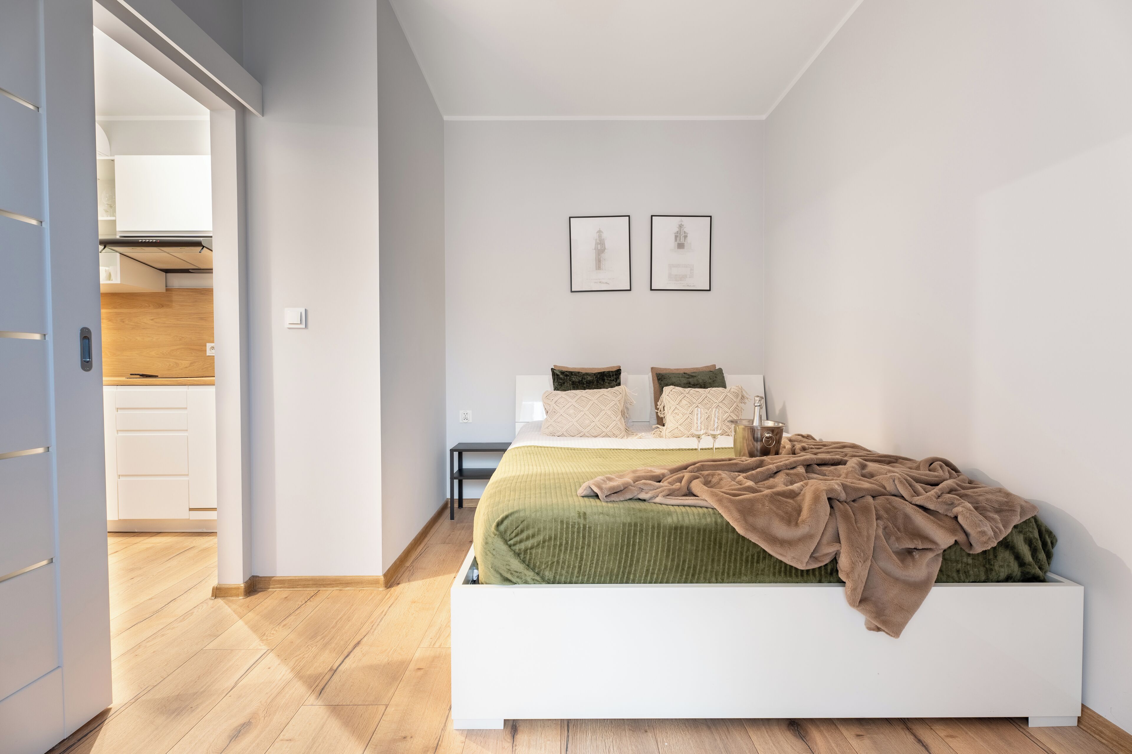 Une chambre à coucher moderne avec un lit, une table de chevet et une étagère fixée au mur.