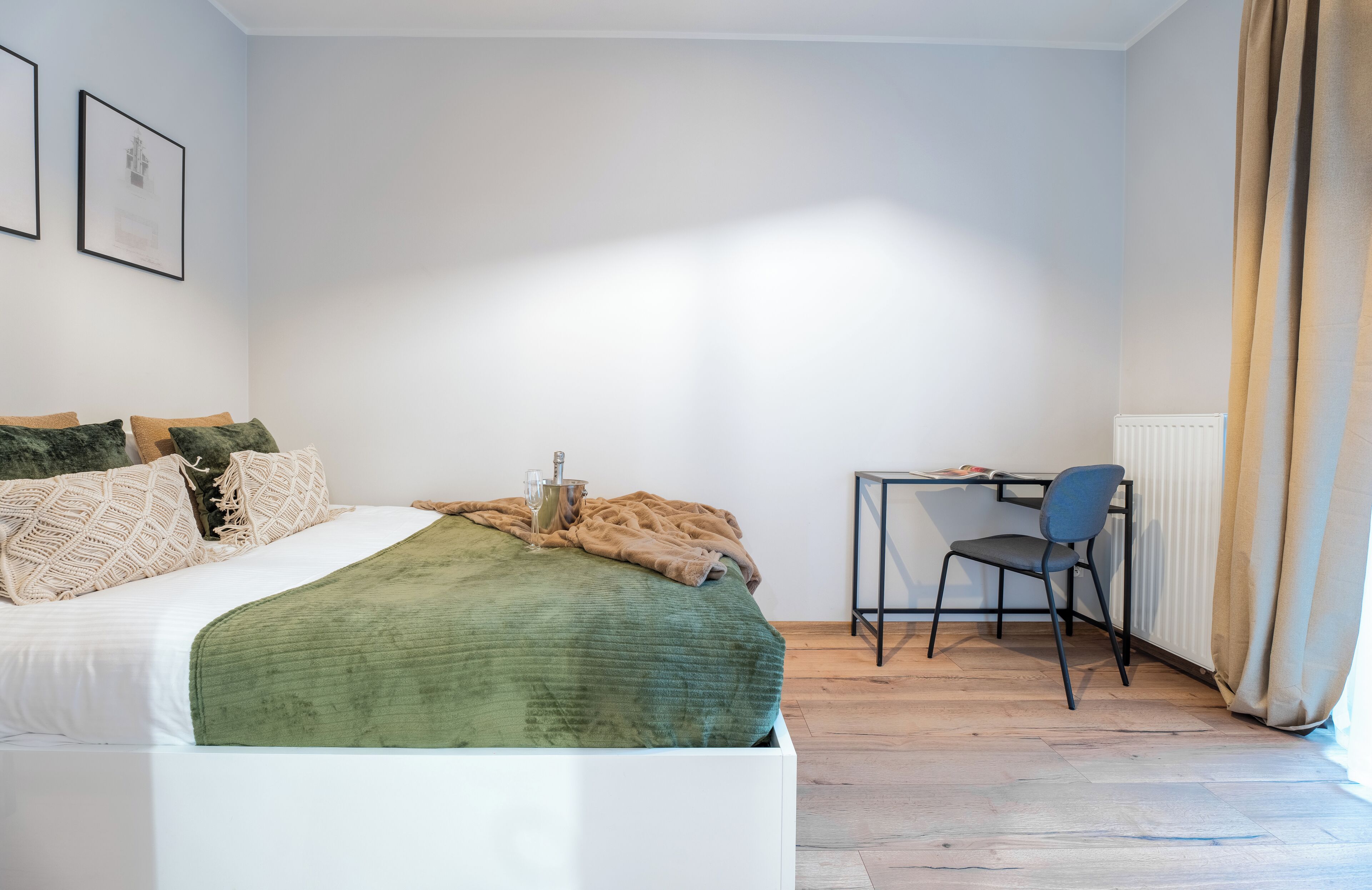 A bedroom with a bed, a desk, and a chair.