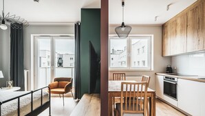 A modern apartment with a dining area, kitchen, and a large window overlooking the city. - Pure Rental Premium Inżynierska (Wrocław)