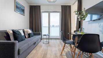 Apartment, Balcony, City View | Living area | 40-inch Smart TV with cable channels