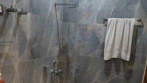 A bathroom with a toilet, sink, and shower area. - Hotel OPM & Restaurant (Agra)