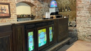 A bar area with a stone wall, a wooden counter, and a coffee machine. - Charming Italian house in Cantarana for 6 guests, 3 bedrooms. (Piemonte)