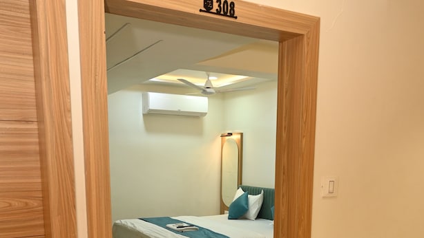 Una habitación de hotel con dos camas, un espejo y un ventilador de techo.
