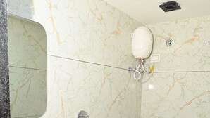 Un baño con pared de mármol, un lavamanos blanco, un bidé y un inodoro.
