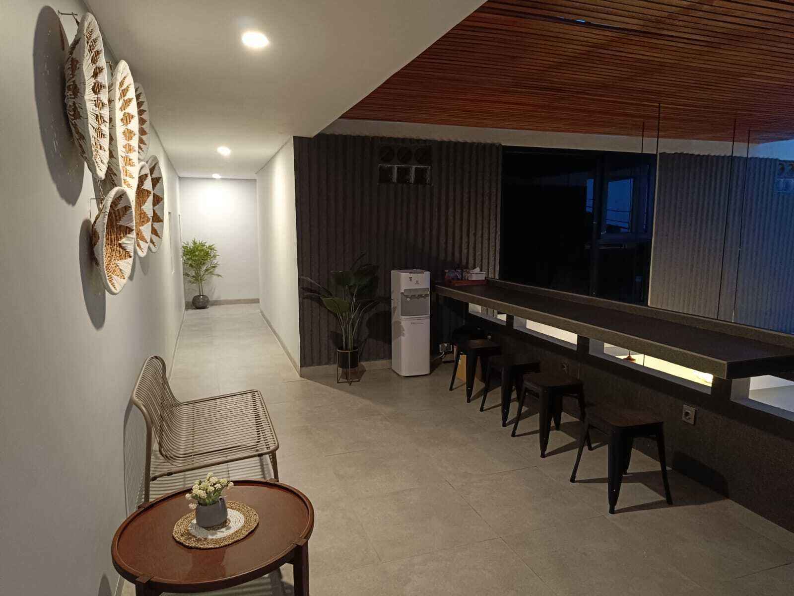 Una cocina moderna con una barra alargada, taburetes y una zona de comedor con mesa y sillas.