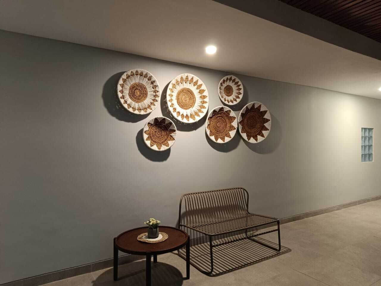 A modern interior with a metal bench and a small round table with a plant.